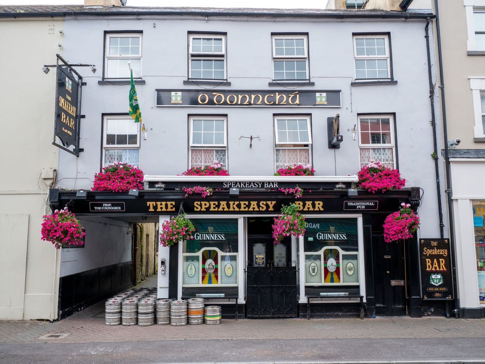 Flower baskets decorate the exterior of The Speakeasy Bar along a street in Killarney town near Killarney National Park.
